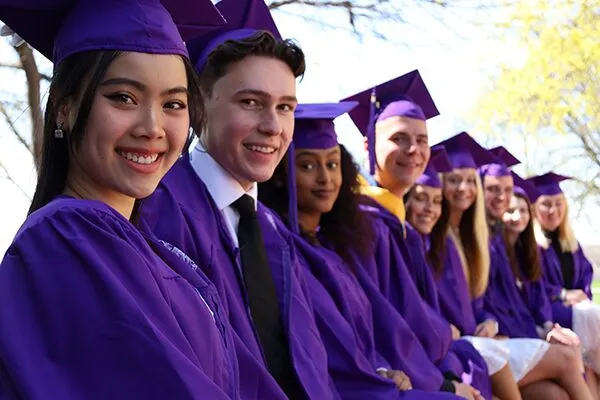 A group of graduating 51ԹϺ students looking at the camera and smiling.