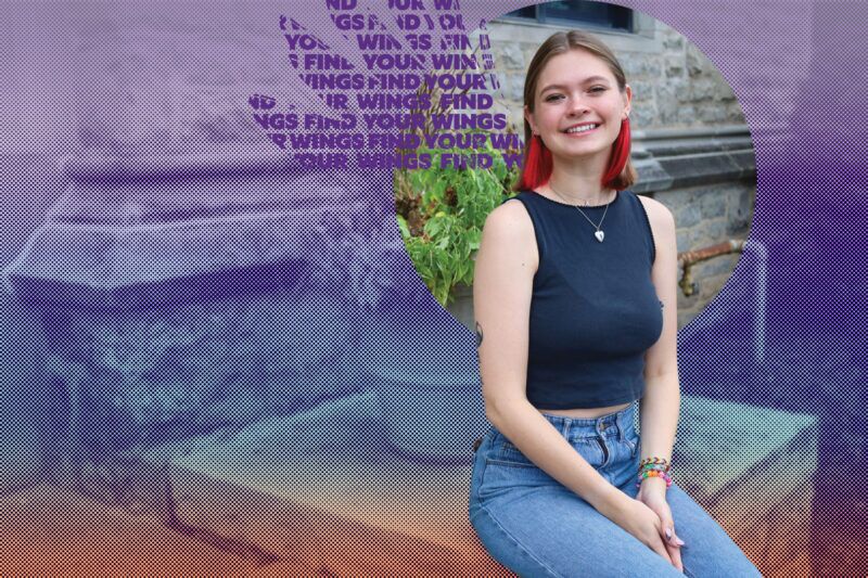 NU Student smiles on the front steps of Gacioch Hall.
