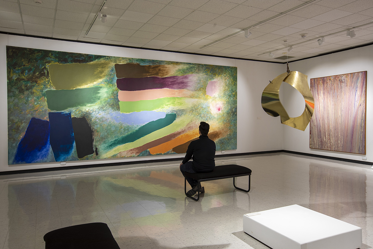 person sitting on a bench viewing a large work in castellani