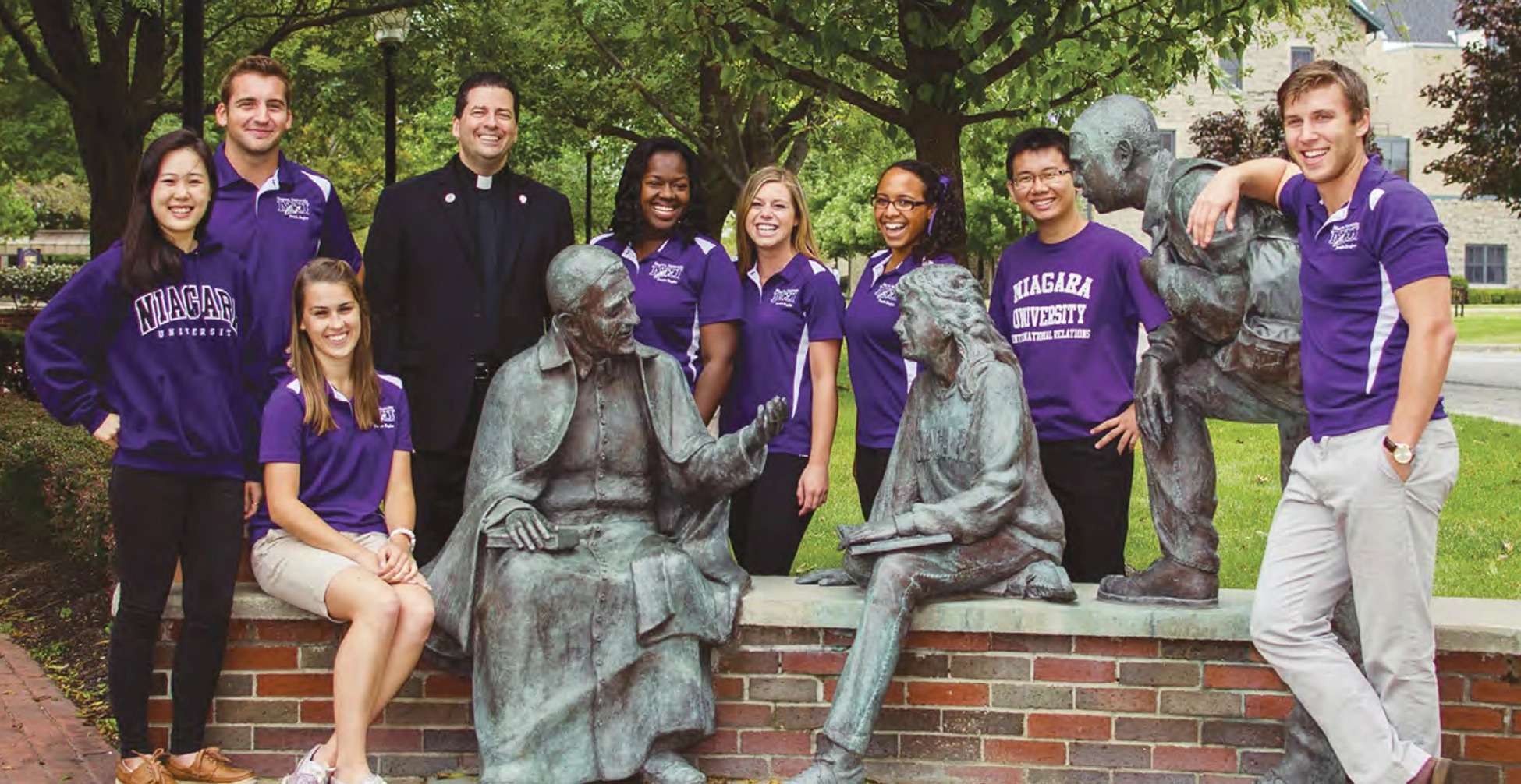 Father Maher and students standing by St Vincent Statue